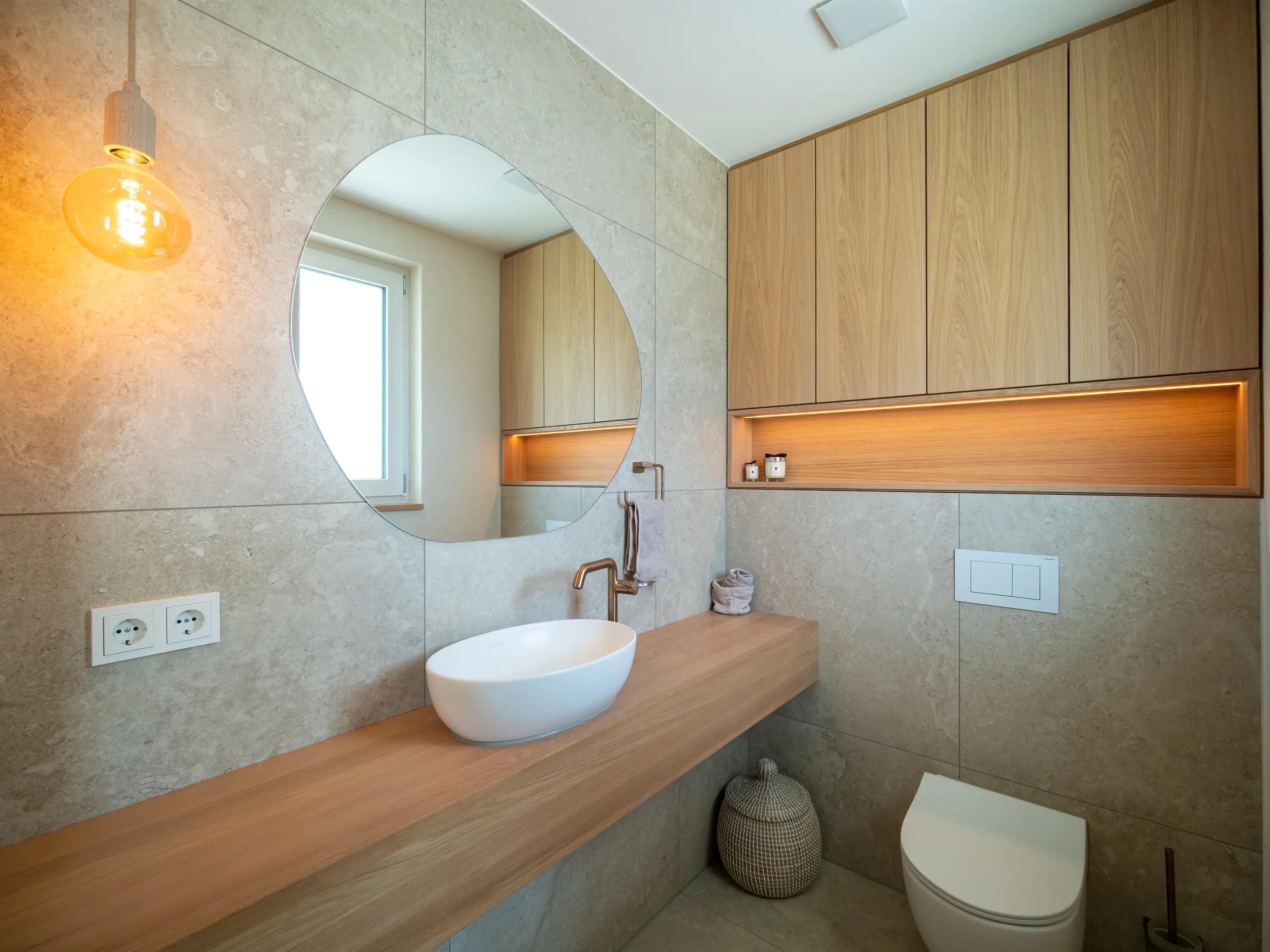Gäste-WC mit rundem Spiegel und Naturstein