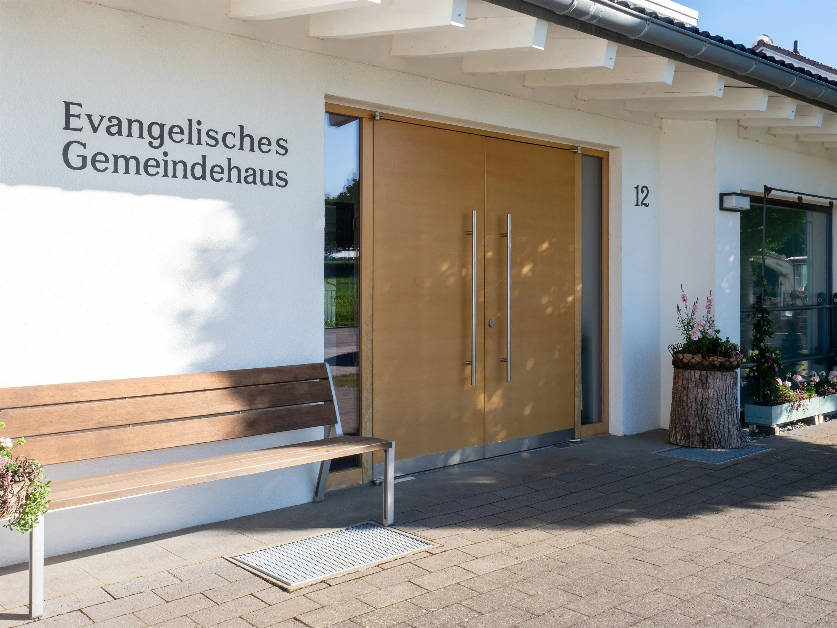 Eingang aus der Nähe mit Schriftzug und Holztür