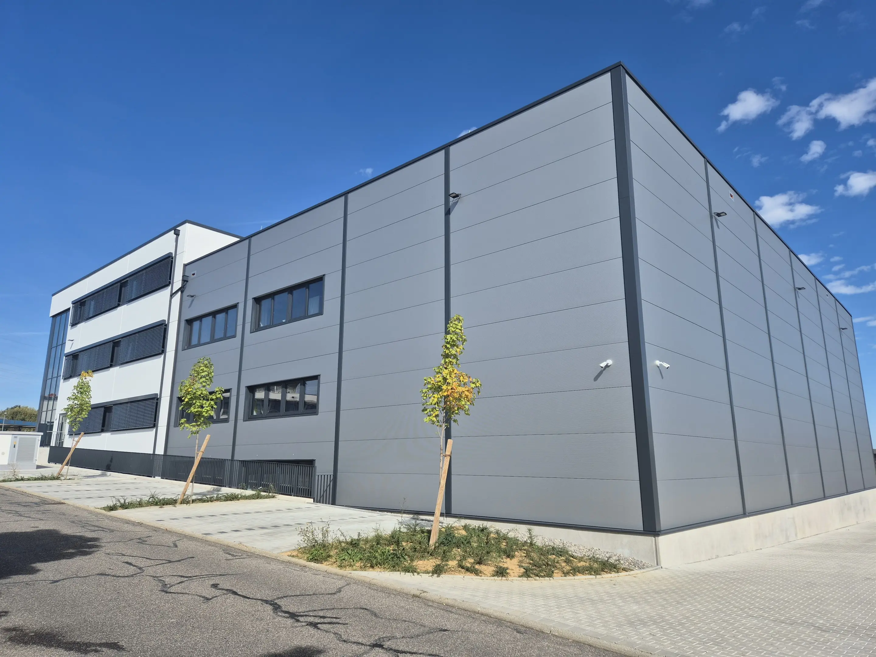 Halle und Büroblock als ein Volumen über Eck