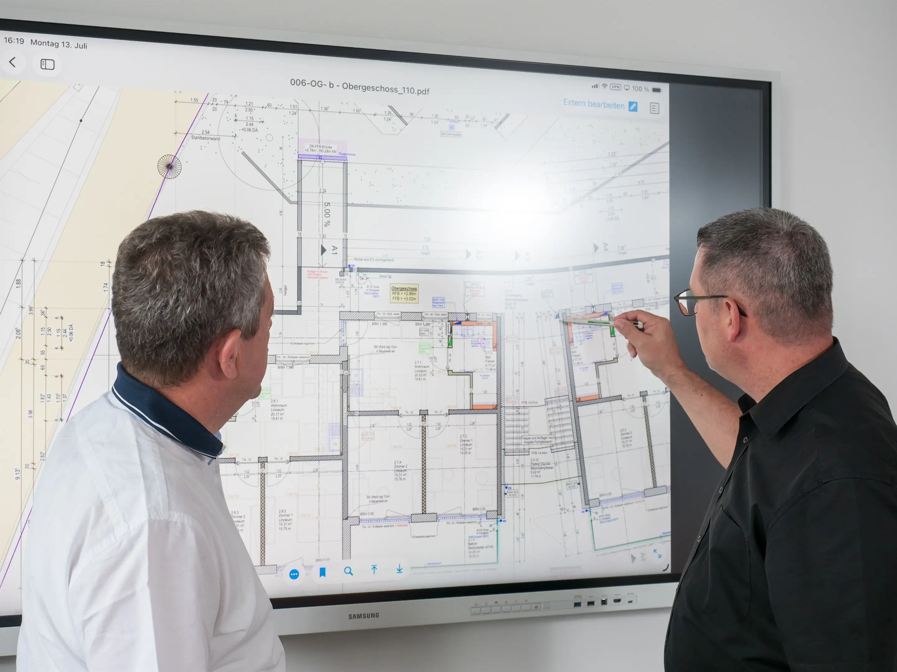 Zwei Planer des Büros besprechen einen Grundriss am digitalen Planungsbildschirm